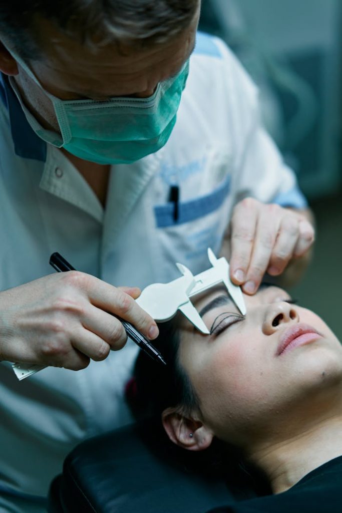 Surgeon measuring patients eyelid before cosmetic surgery in medical clinic setting.
